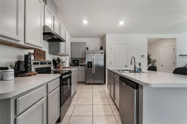 a kitchen with stainless steel appliances a sink stove and cabinets