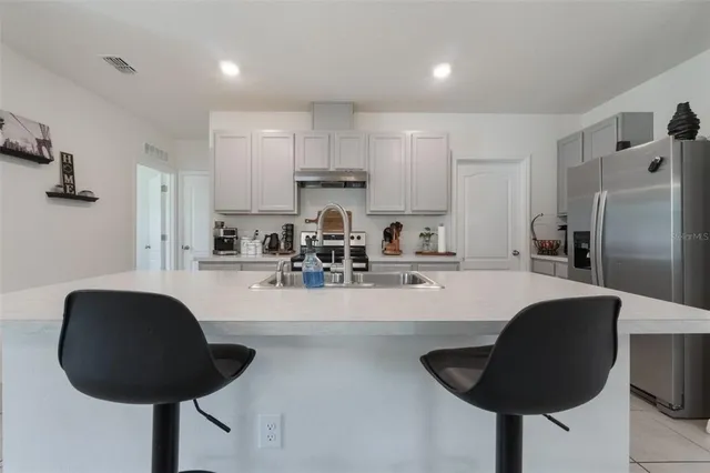 a kitchen with granite countertop a counter space a sink stainless steel appliances and cabinets
