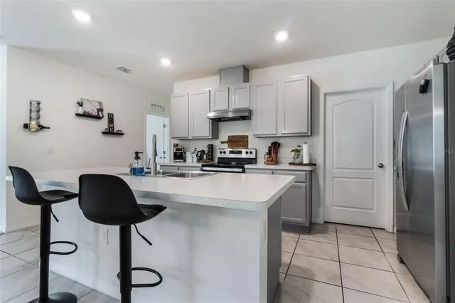 a kitchen with cabinets and chairs
