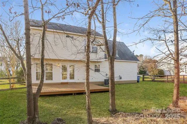 a view of a house with backyard and a tree