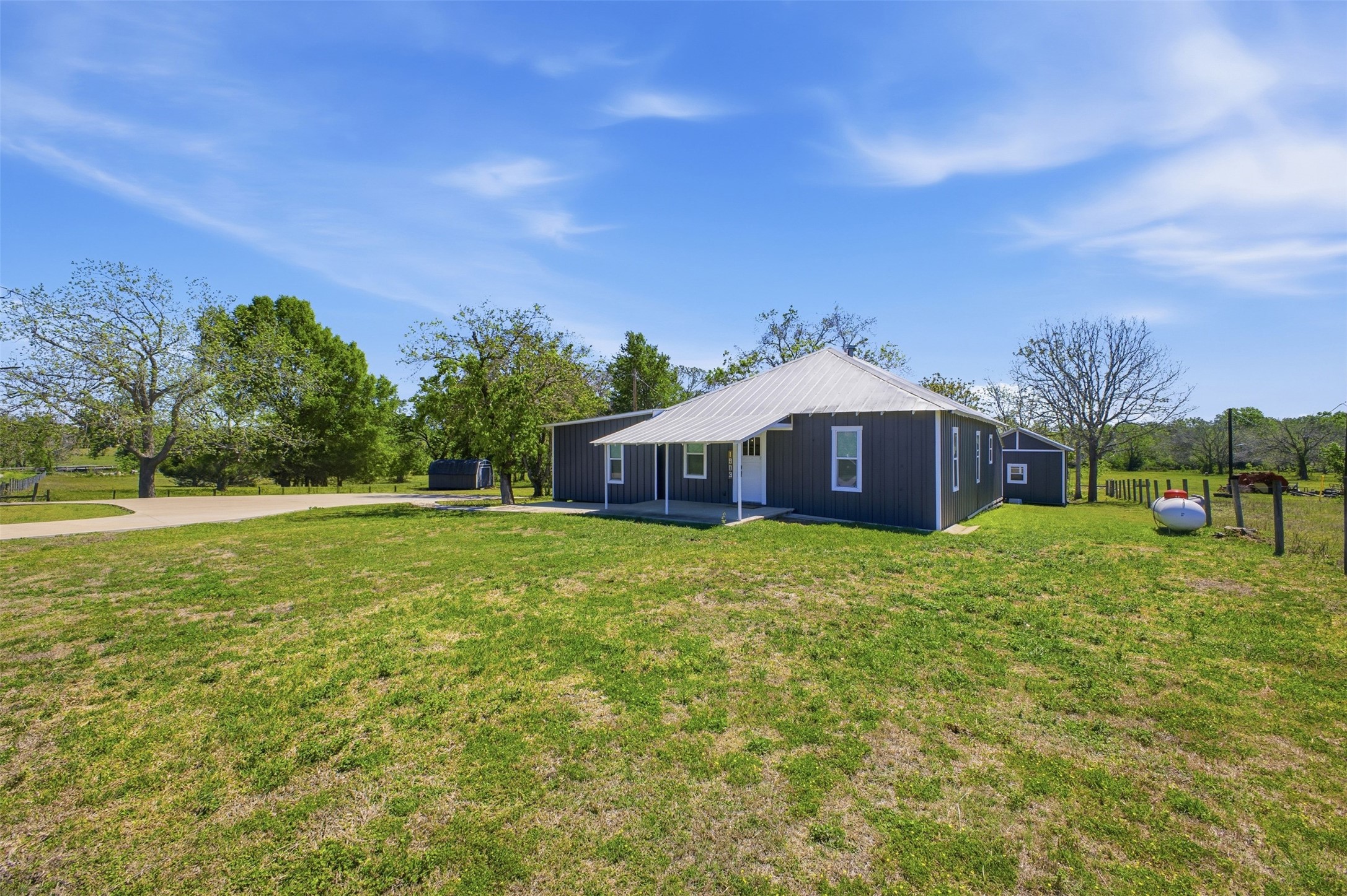 1903 Tigerpoint Road Brenham, TX 77833 - Photo 2 of 27 a yellow house with a big yard and large trees