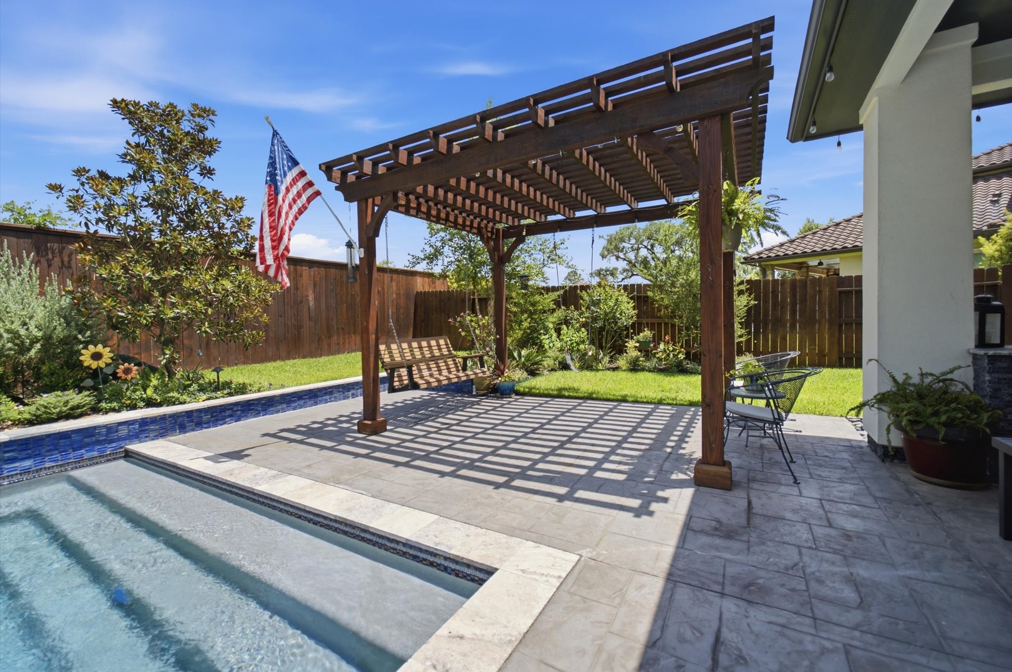 23722 Thortons Park Lane Spring, TX 77389 - Photo 44 of 48 This backyard features a serene swimming pool and a stylish pergola, perfect for outdoor relaxation and entertaining. The area is landscaped with greenery and enclosed by a wooden fence for privacy. A small patio area provides space for seating and dining.