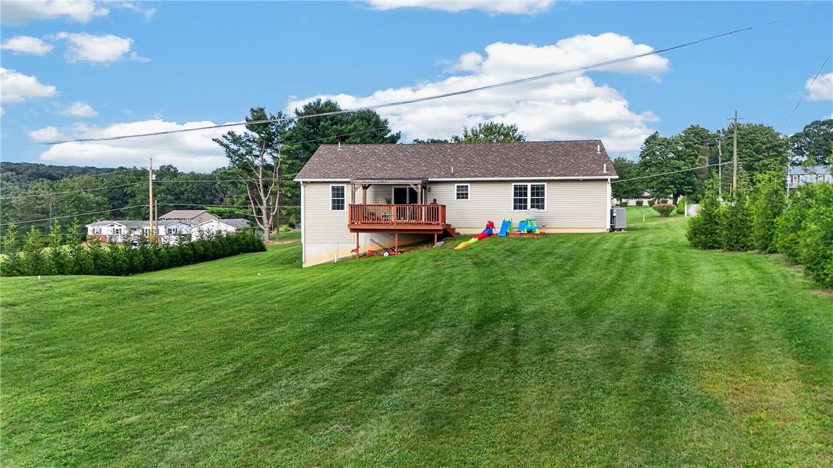 74 Kepners Road New Ringgold, PA 17960 - Photo 30 of 79 An expansive green lawn stretches toward a elevated wood deck and modern vinyl-sided exterior.