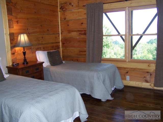 268 Old Megs Lane Boone, NC 28607 - Photo 3 of 12 a bedroom with a bed and a lamp next to a window