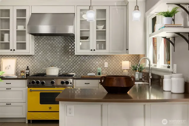 a kitchen with a stove and a white wooden cabinets
