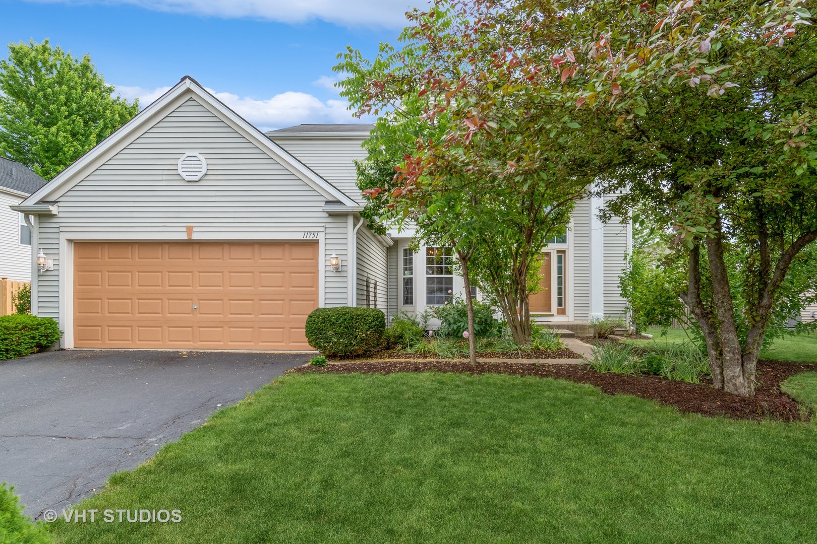 a front view of a house with a garden and yard