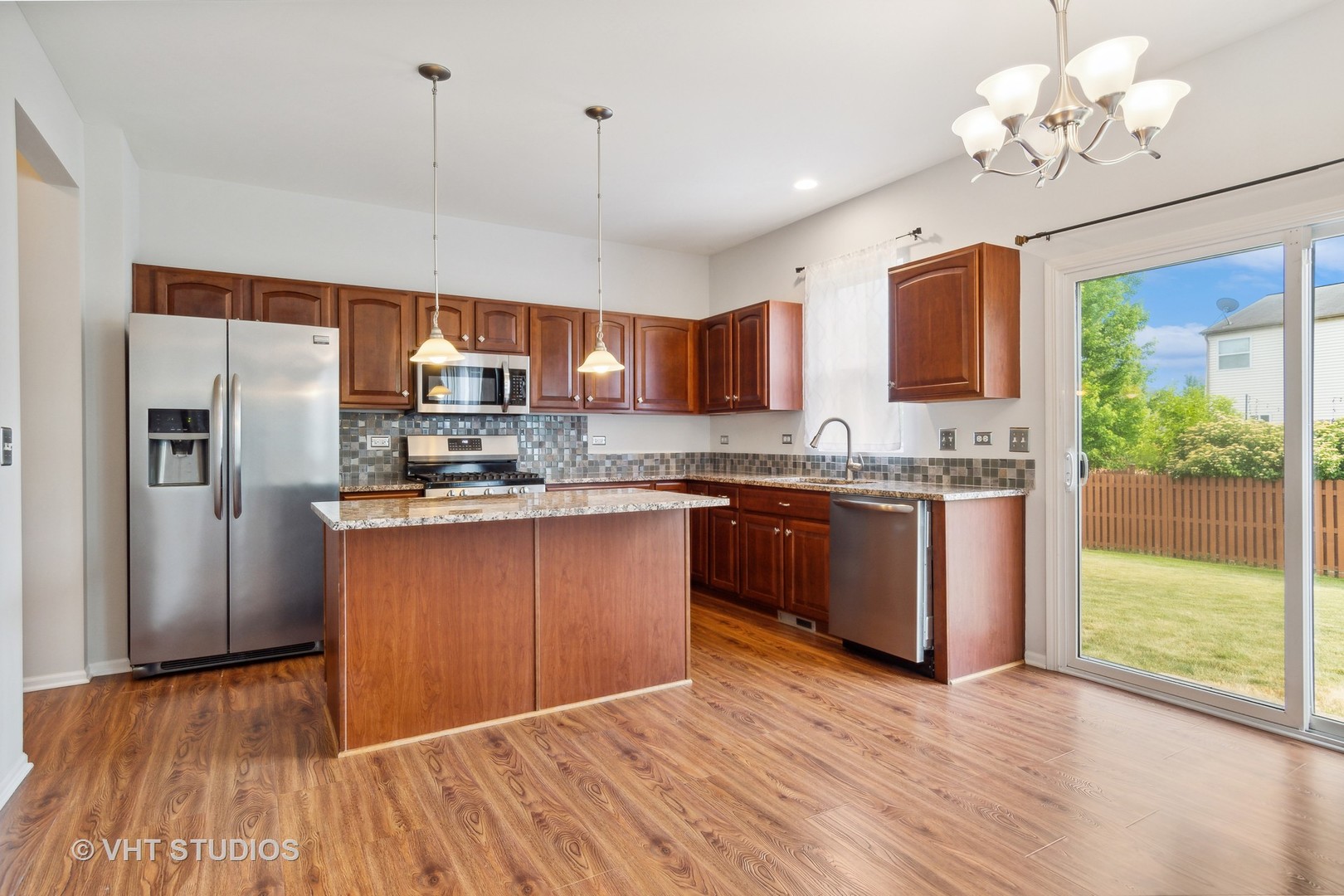 11751 Glenn Circle Plainfield, IL 60585 - Photo 5 of 19 a kitchen with stainless steel appliances granite countertop a refrigerator a sink dishwasher a stove and white countertops with wooden floor