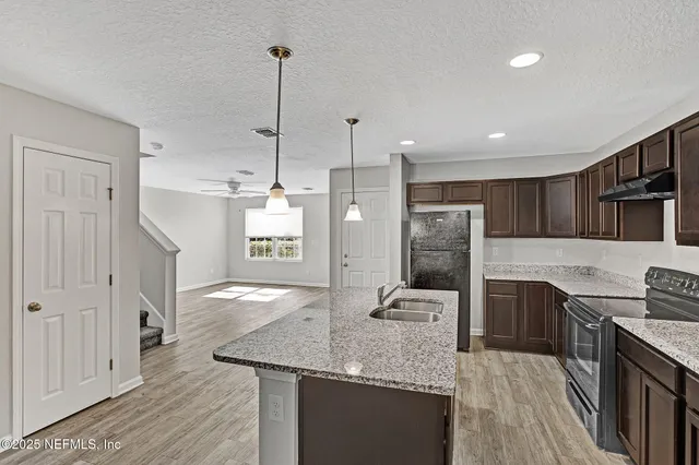 a kitchen with stainless steel appliances granite countertop a sink refrigerator and cabinets