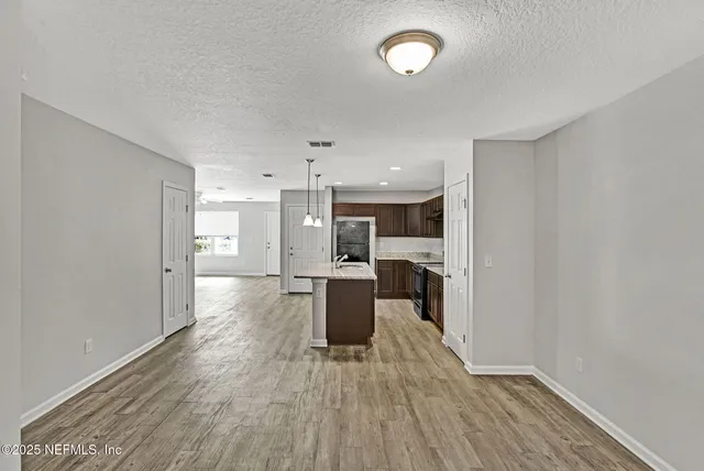 a view of a dining room with furniture a kitchen and chandelier