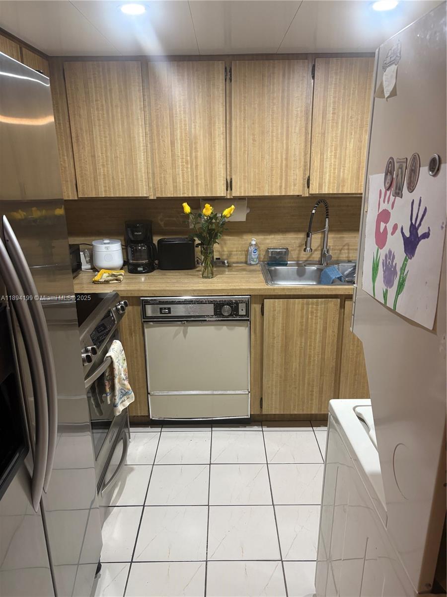 1350 Southwest 122nd Avenue, Unit 423 Miami, FL 33184 - Photo 4 of 8 a kitchen with a cabinets a sink and a stove top oven