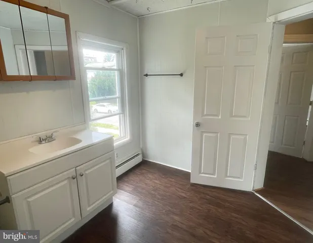 a view of a kitchen with wooden floor and cabinets