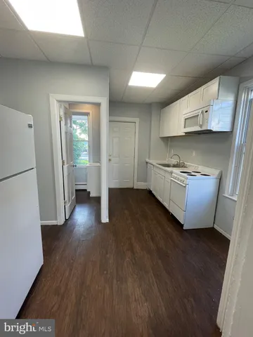 a living room with stainless steel appliances wooden floors and view living room