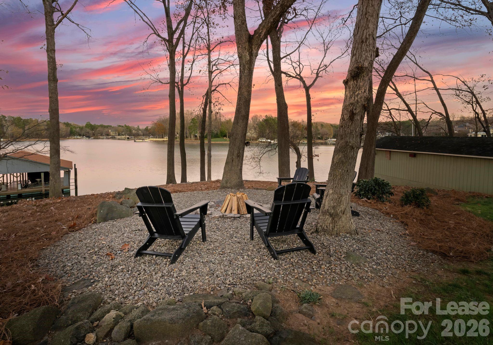 19709 Stough Farm Road Cornelius, NC 28031 - Photo 37 of 48 a view of a lake with a bench and trees