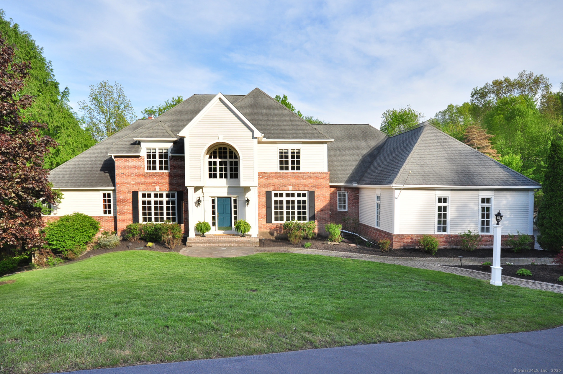 a front view of a house with a yard and green space