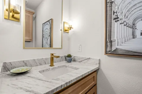a bathroom with a granite countertop sink and a mirror