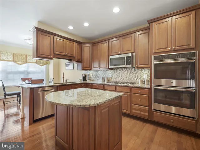 a kitchen with stainless steel appliances granite countertop a sink stove and microwave