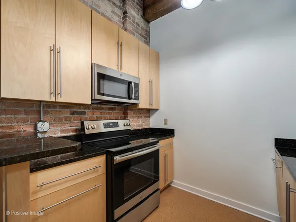 a kitchen with stainless steel appliances a stove a microwave and sink