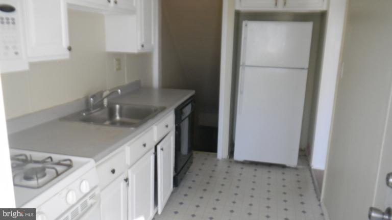 419 Oakwood Road Baltimore, MD 21222 - Photo 6 of 16 a kitchen with a sink and cabinets