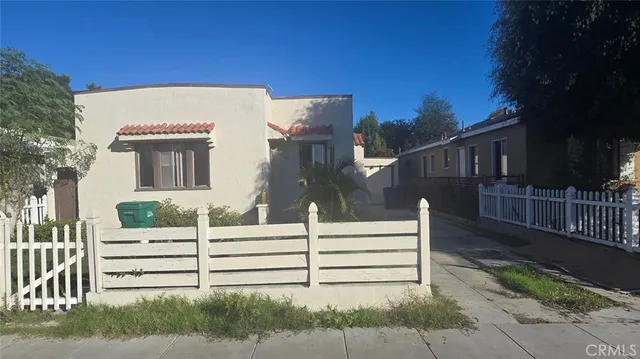 a view of a house with wooden fence