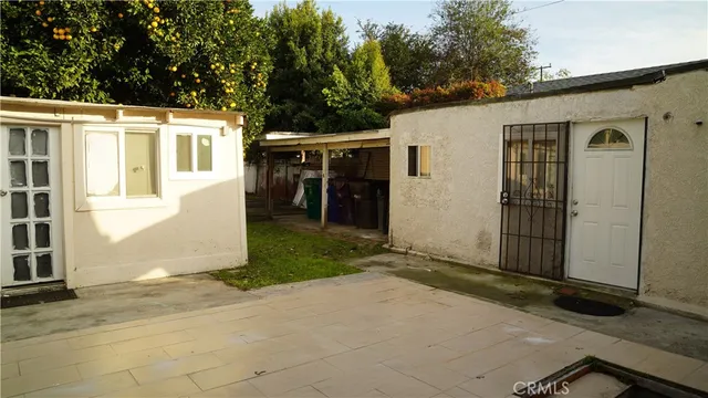 a view of a house with backyard and trees