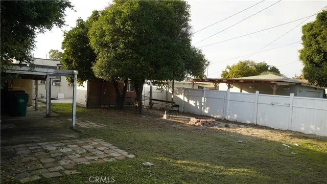 a view of a backyard with wooden fence