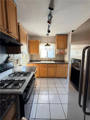 a kitchen with a stove a sink dishwasher and a refrigerator