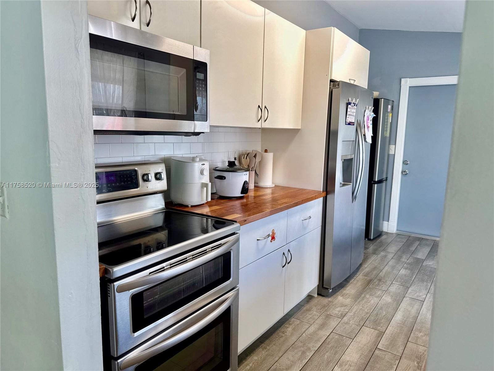 13065 Southwest 263rd Terrace Homestead, FL 33032 - Photo 5 of 19 a kitchen with stainless steel appliances a stove microwave and sink