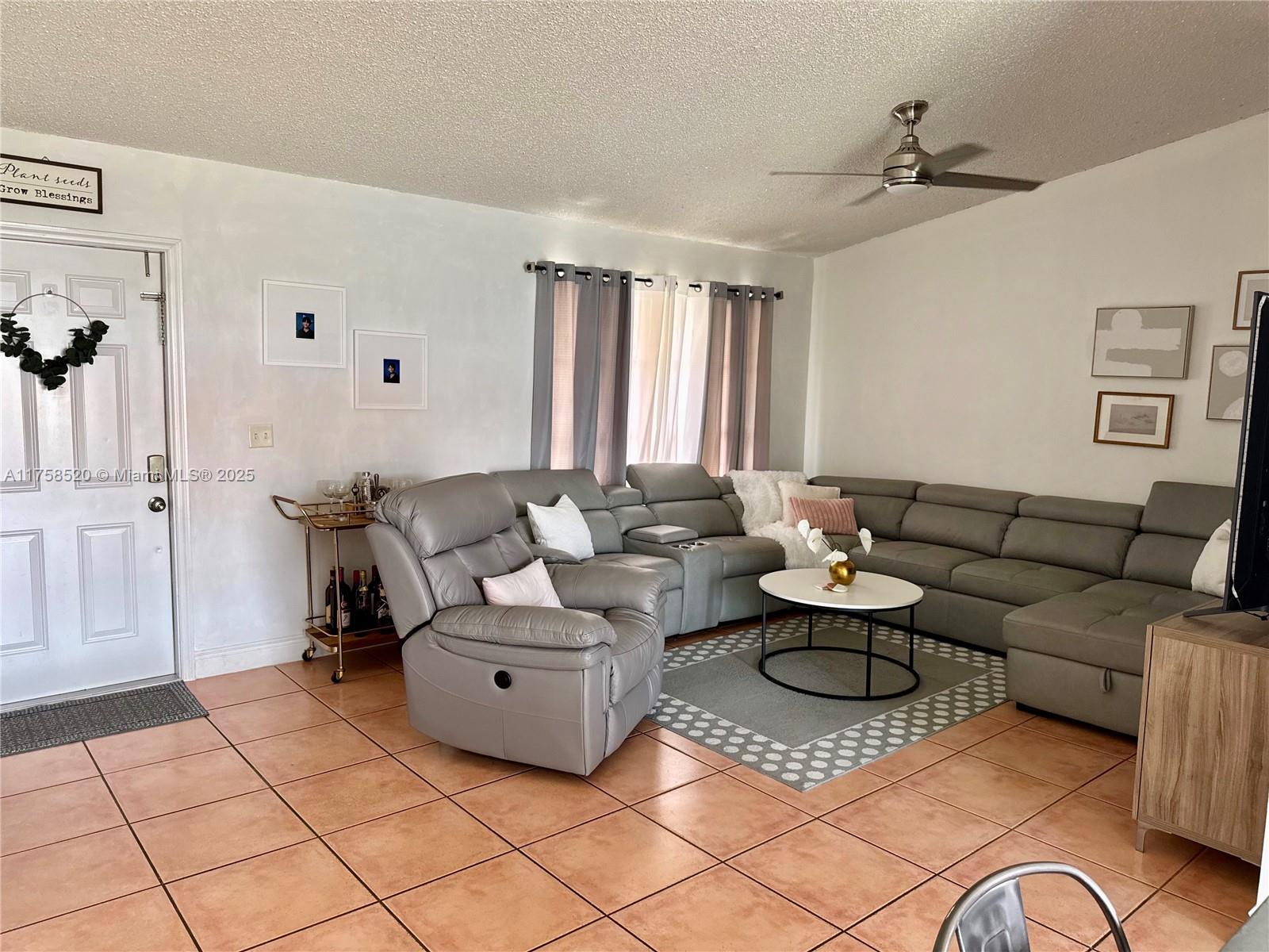 13065 Southwest 263rd Terrace Homestead, FL 33032 - Photo 10 of 19 a living room with furniture a large window and a table