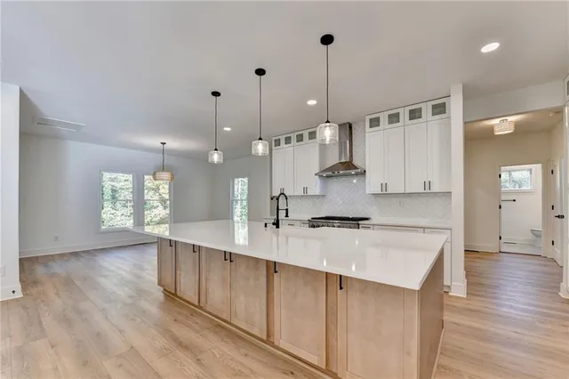 a large kitchen with kitchen island a stove a sink a refrigerator and wooden floor