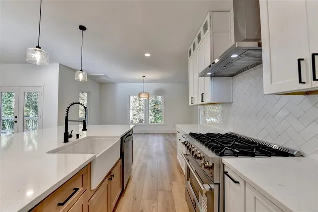 a kitchen with stainless steel appliances a sink stove and cabinets