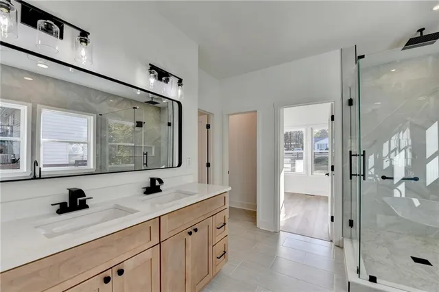 a bathroom with a double vanity sink mirror and shower