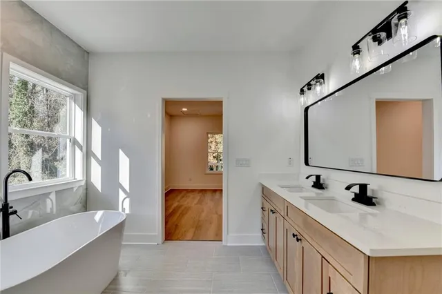 a bathroom with a tub sink and mirror