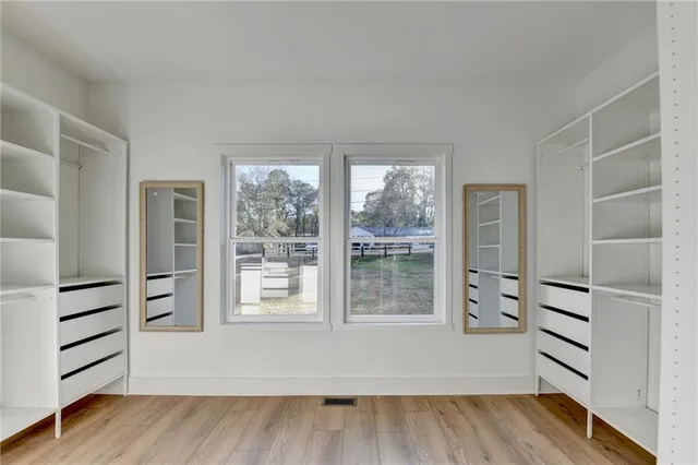 an empty room with wooden floor and windows