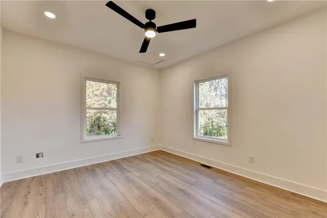 a view of an empty room with a window and wooden floor