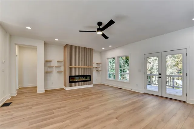 a view of an empty room with window and wooden floor