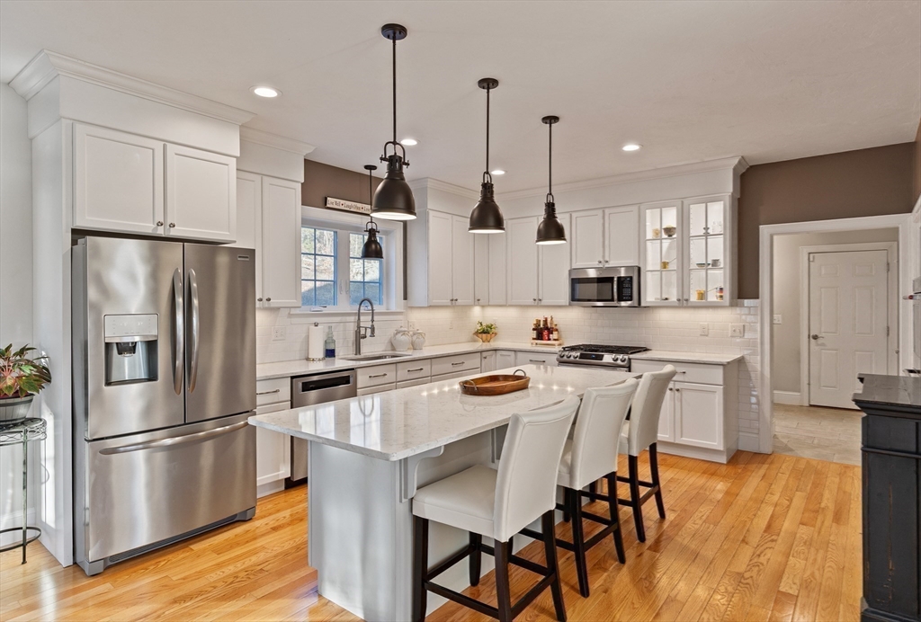 7 Jewell Crossing Mendon, MA 01756 - Photo 6 of 42 a kitchen with stainless steel appliances a refrigerator a stove a sink and chairs