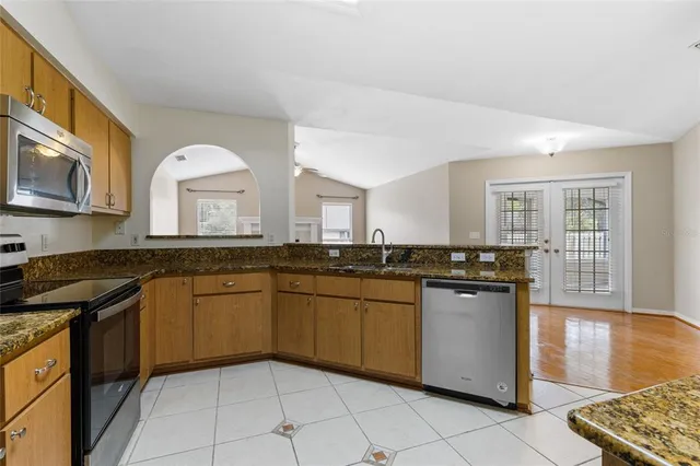 a kitchen with stainless steel appliances granite countertop a sink and a stove