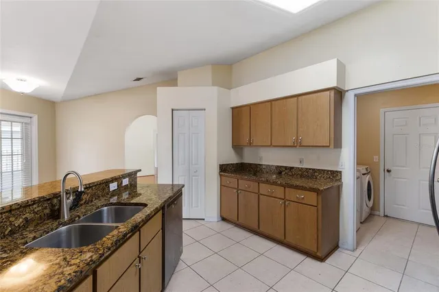 a kitchen with granite countertop a sink stove and cabinets