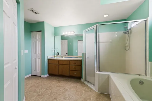 a bathroom with a tub sink shower and mirror