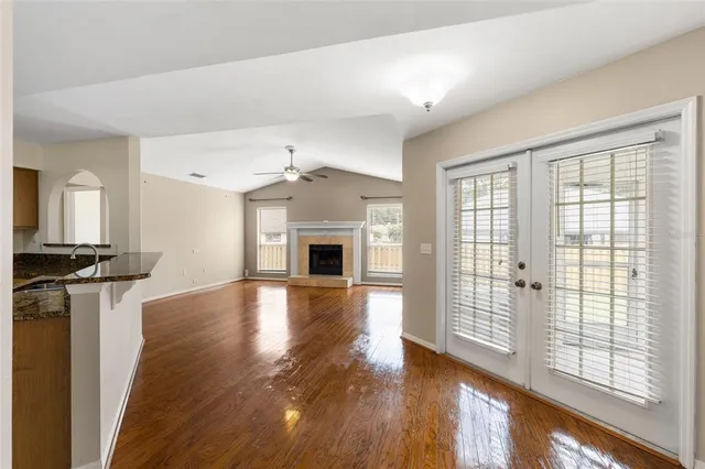 a view of empty room with wooden floor and fireplace