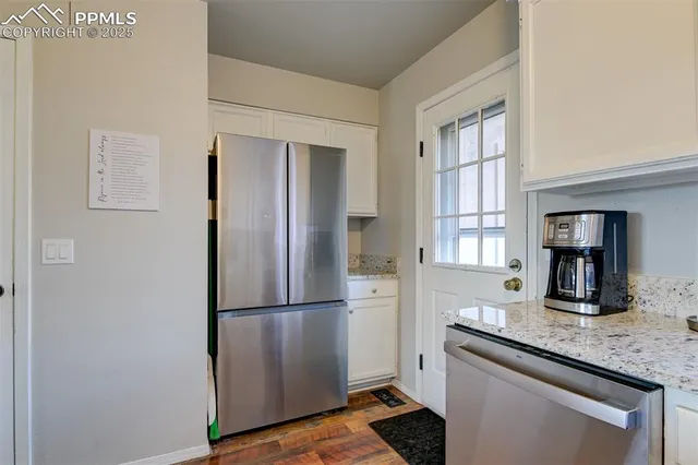 a kitchen with granite countertop a refrigerator and a sink