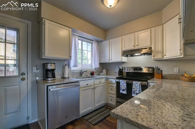 a kitchen with stainless steel appliances granite countertop a sink stove and cabinets