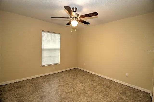 an empty room with closet and a chandelier fan