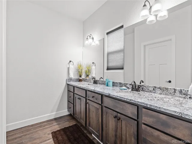 a bathroom with a granite countertop sink and a mirror