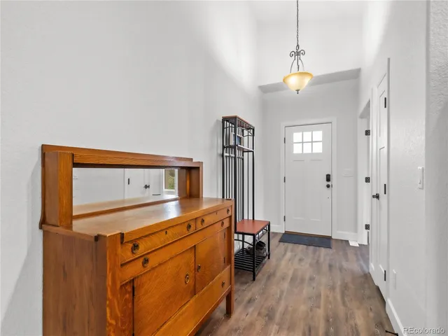 a view of a room with a bed and wooden floor