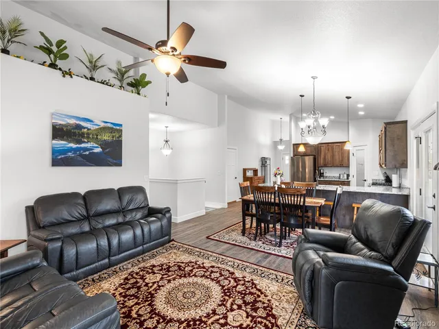 a living room with furniture kitchen view and a chandelier