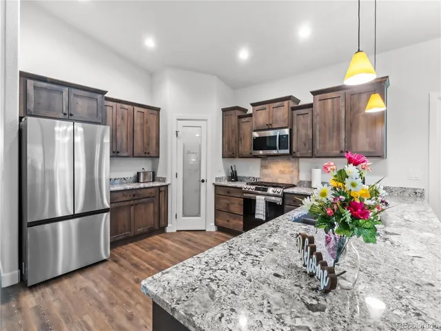 a kitchen with stainless steel appliances kitchen island granite countertop a refrigerator stove microwave and sink
