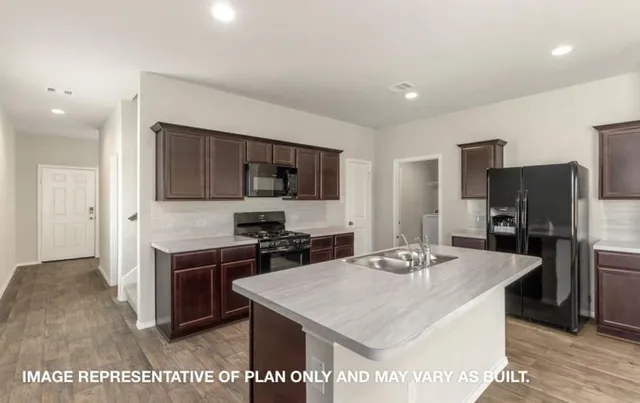 a kitchen with stainless steel appliances a stove top oven a refrigerator a sink and a refrigerator