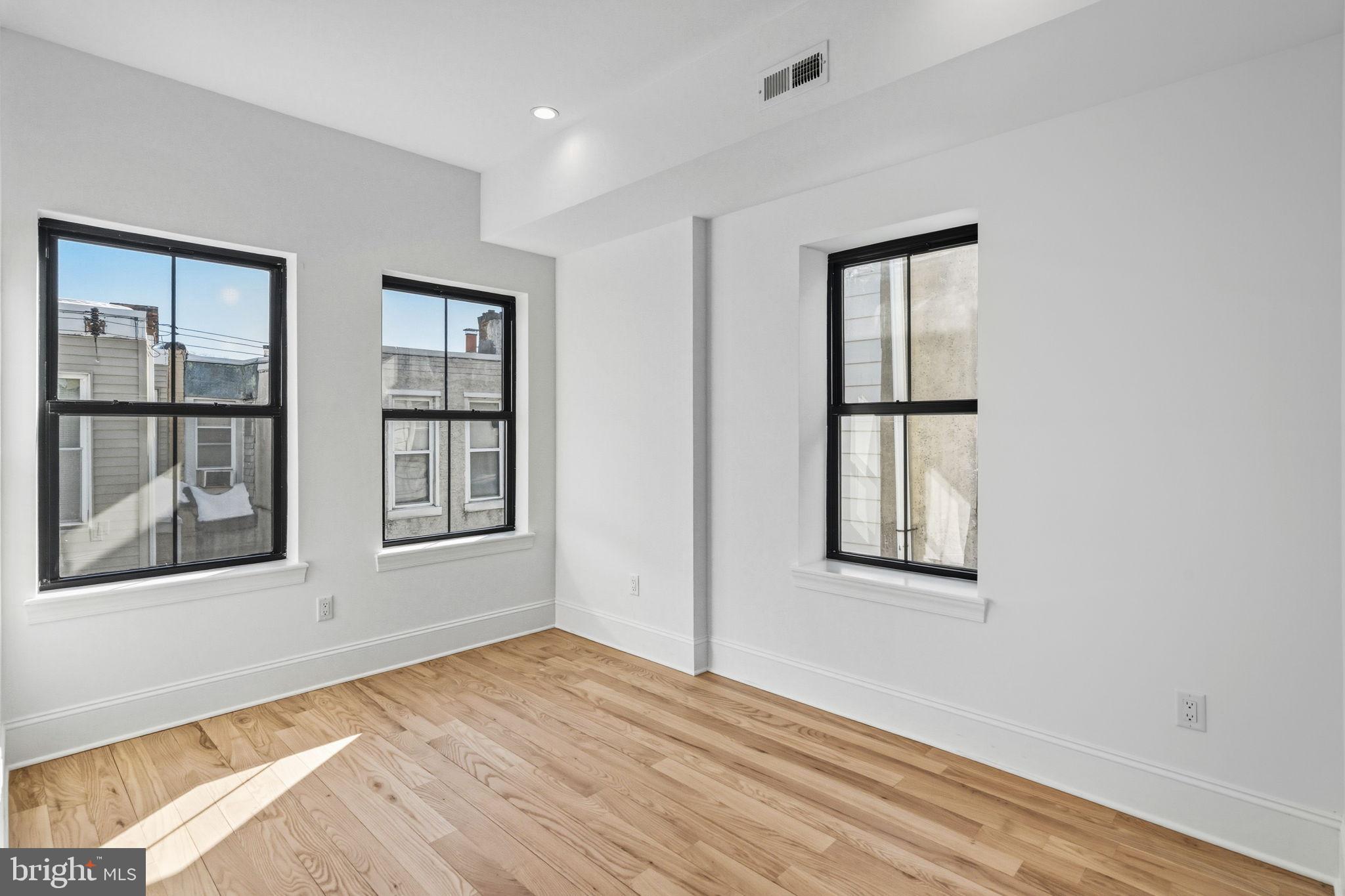1635 South 5th Street Philadelphia, PA 19148 - Photo 29 of 60 a view of an empty room with a window and wooden floor
