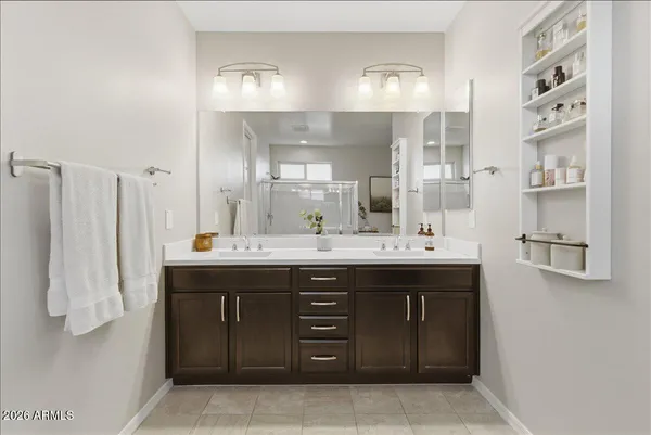 a spacious bathroom with a double vanity sink a mirror and shower